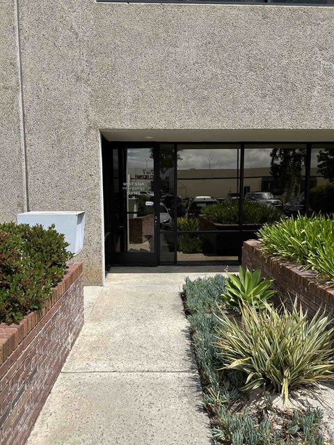 A building with a grey wall and a glass door.