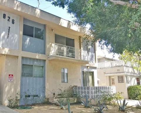 A two-story building with a balcony and a blue door.