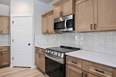 A kitchen with wooden cabinets and a black stove top oven.