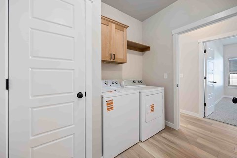 A white door is open to a room with a washer and dryer.