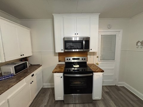 A kitchen with a stove top oven and microwave.
