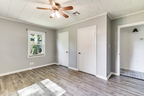 A room with a ceiling fan and a window.
