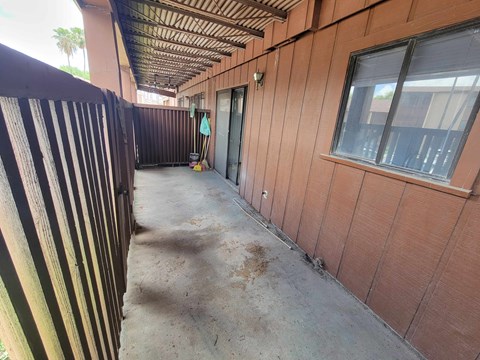 A long corridor with a fence on the left and a building on the right.