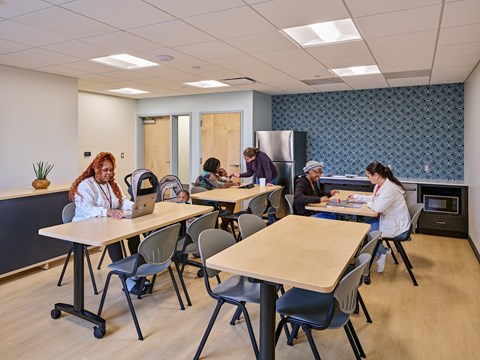 A group of people are sitting around tables in a room.
