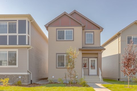 A house with a red roof and a white door is surrounded by other houses.