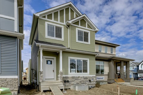 A house under construction with a grey and green exterior.