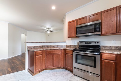 A kitchen with brown cabinets and a stainless steel oven.