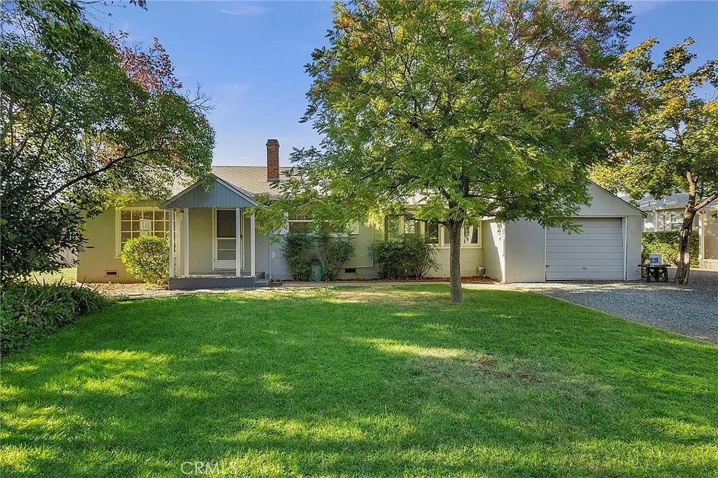 A house with a well-kept lawn and trees in the background.