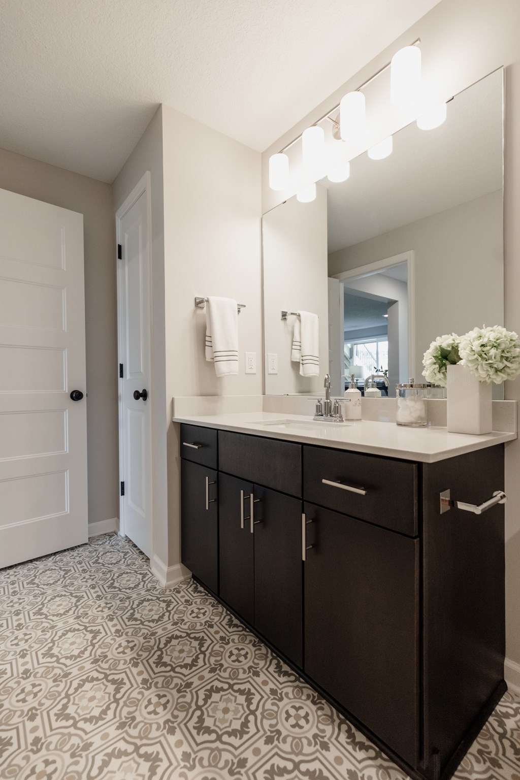 A bathroom with a vanity and a mirror above it.