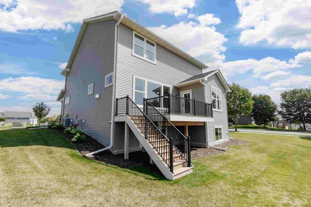 A house with a grey exterior and a black railing on the balcony.