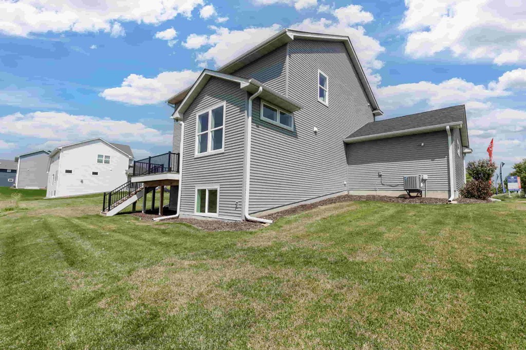 A grey house with a black fence and a small porch.