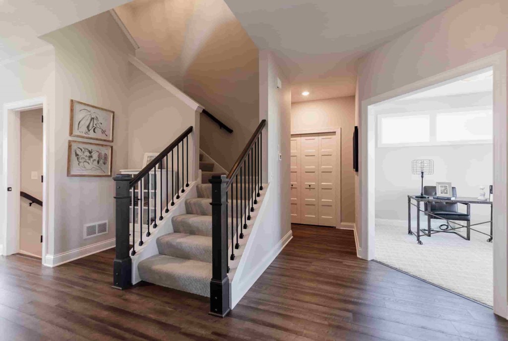 A staircase with a black railing and wooden steps leads to a second floor.