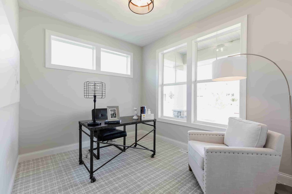 A room with a desk, chair, and window.