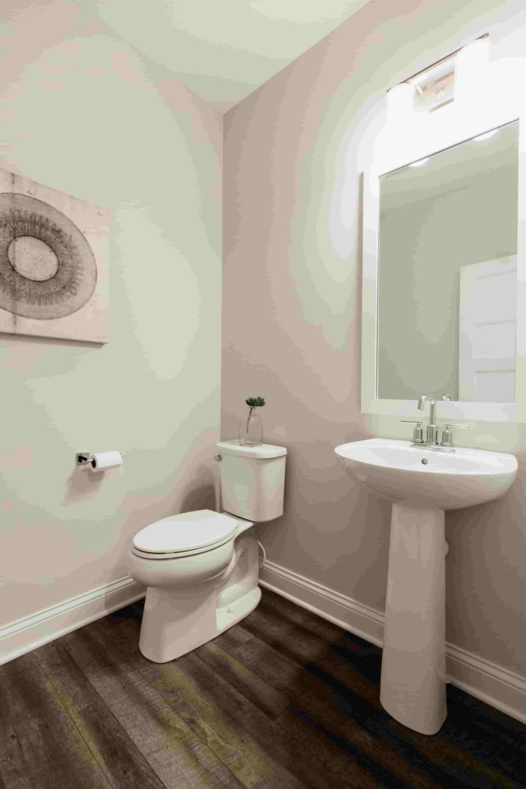 A bathroom with a toilet, sink, and rug.