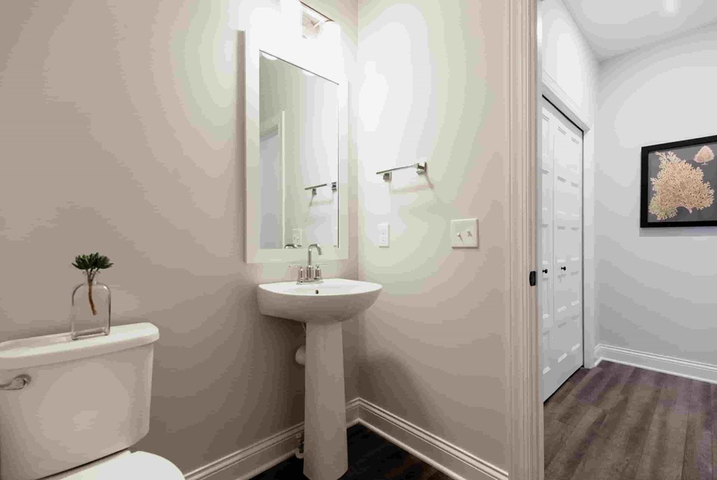 A bathroom with a white sink and a white toilet.