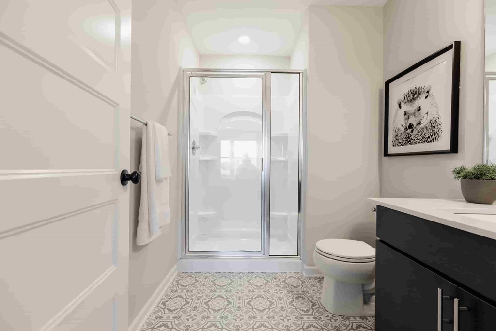 A bathroom with a toilet, sink, and a glass door.