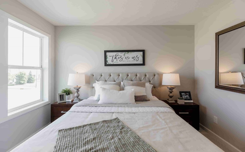 A bedroom with a large bed and a mirror on the wall.