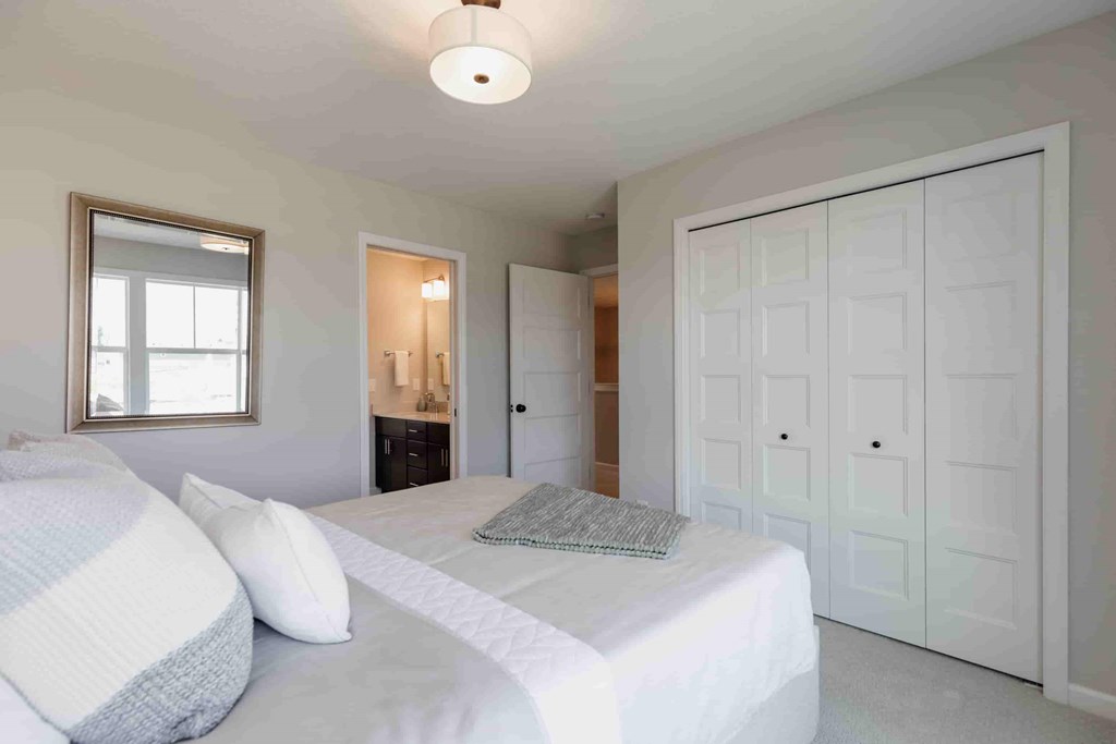 A bedroom with two beds and a large white wardrobe.