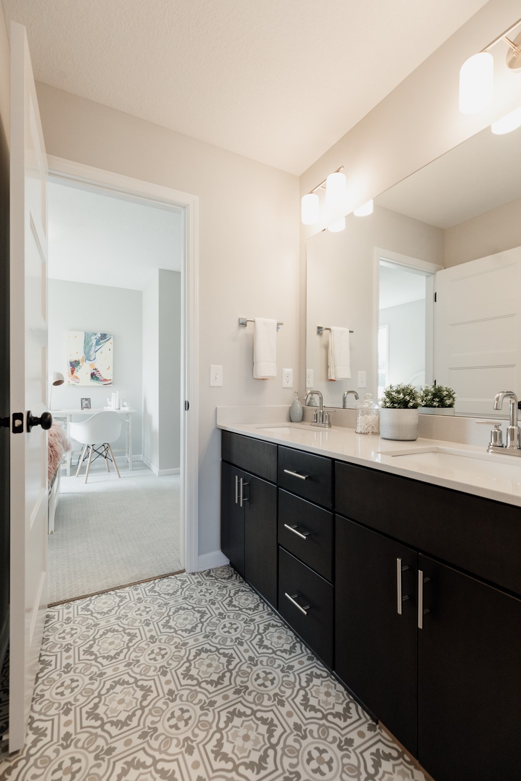 A bathroom with a patterned floor and a sink.