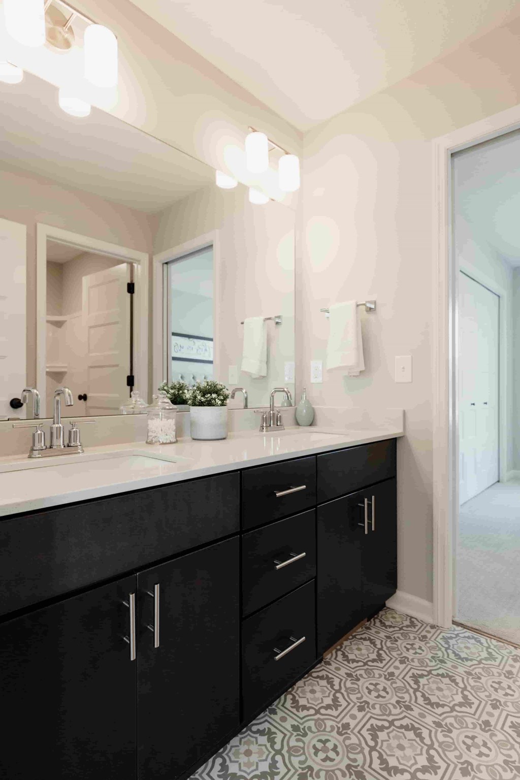A bathroom with black cabinets and a patterned floor.