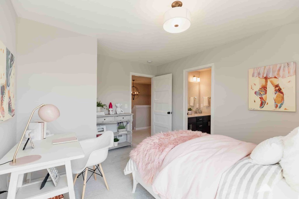 A bedroom with a bed, desk, and chair.