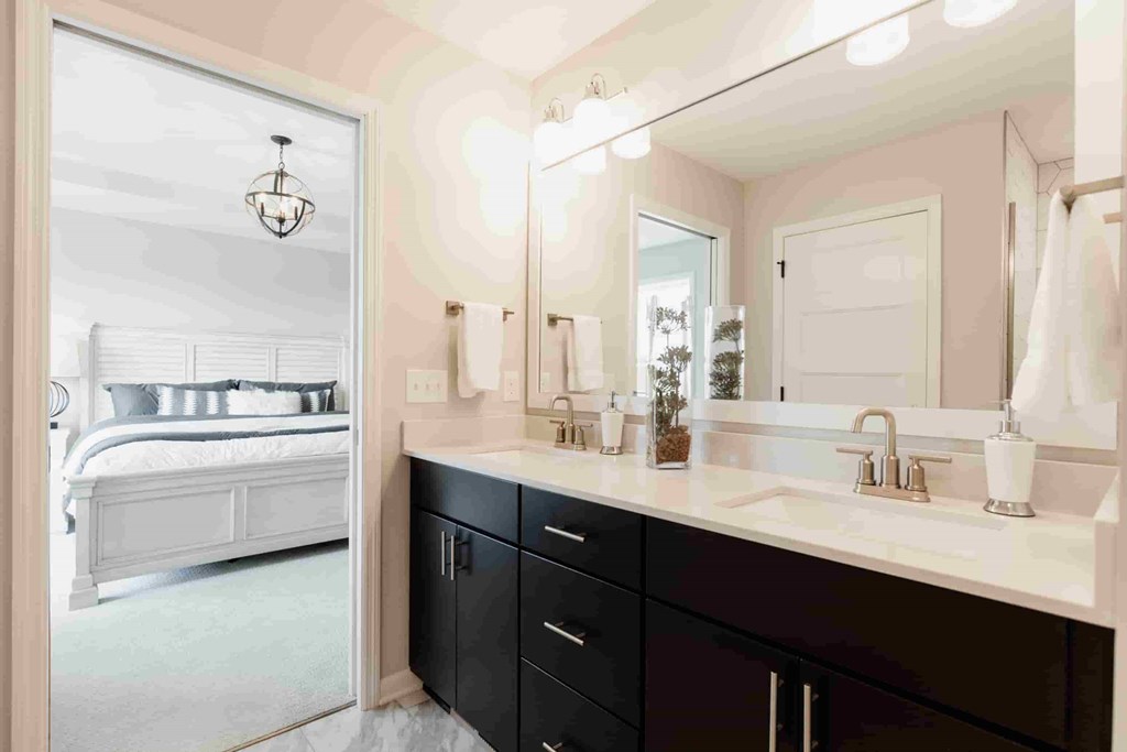 A bathroom with a vanity, sink, and mirror.