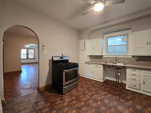 A kitchen with a black stove top oven and white cabinets.