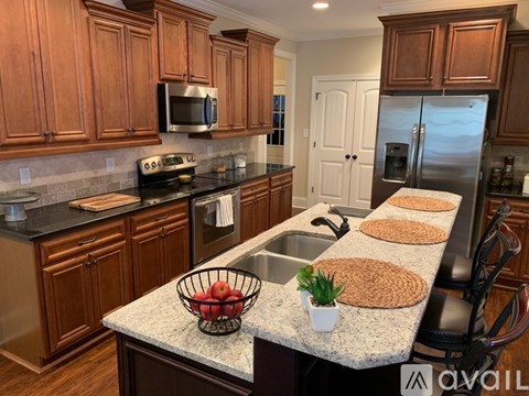 A kitchen with brown cabinets and a granite countertop.