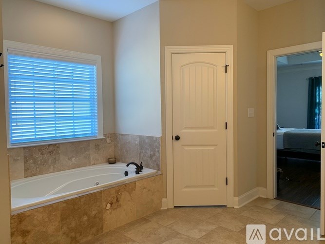 A bathroom with a tub and a door.