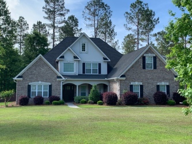 A large house with a black roof and white walls.