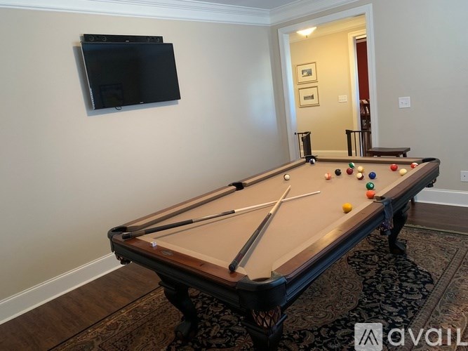 A pool table with a television above it in a room.