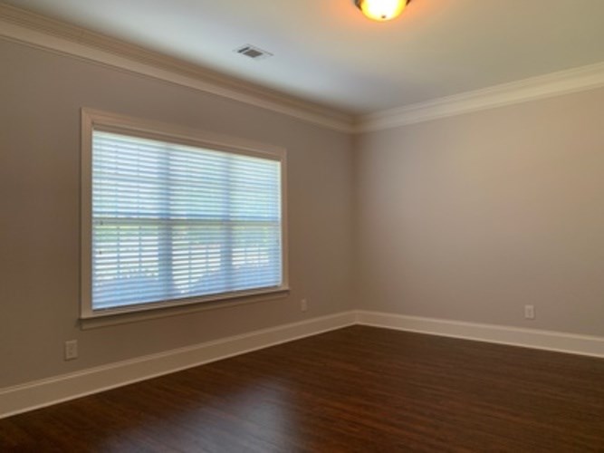 A room with a window and wooden floors.