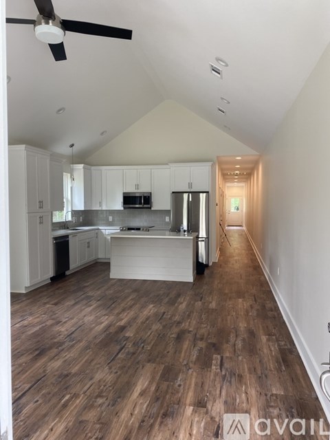 A kitchen with white cabinets and a wooden floor.