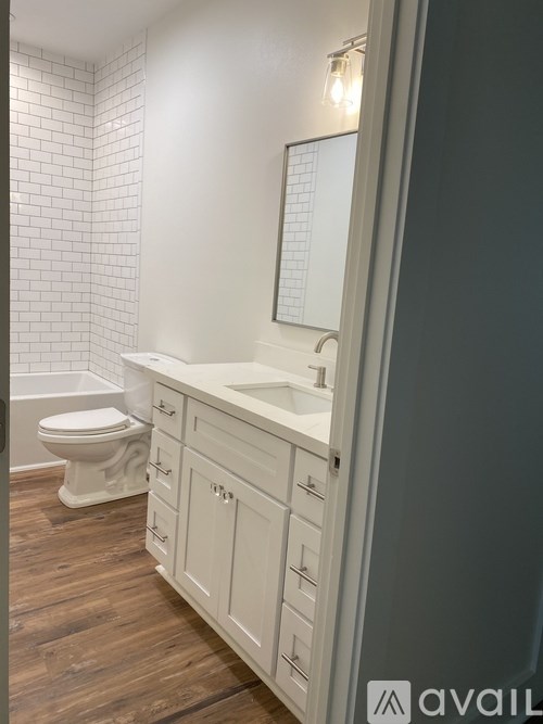 A bathroom with a toilet, sink, and mirror.