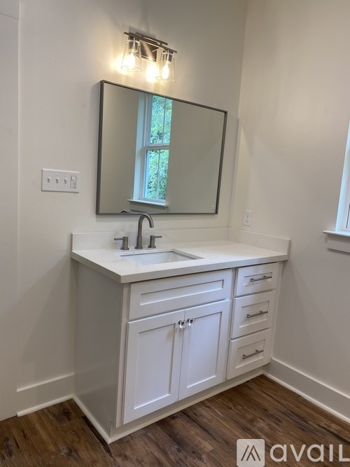 A bathroom vanity with a mirror and lights above it.