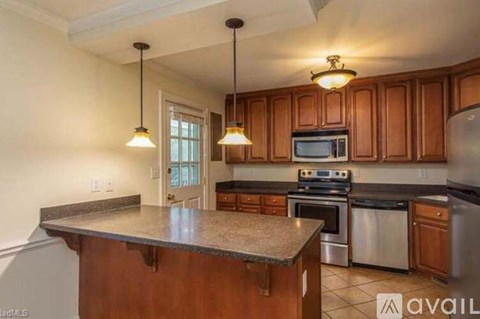 A kitchen with wooden cabinets and a granite countertop.