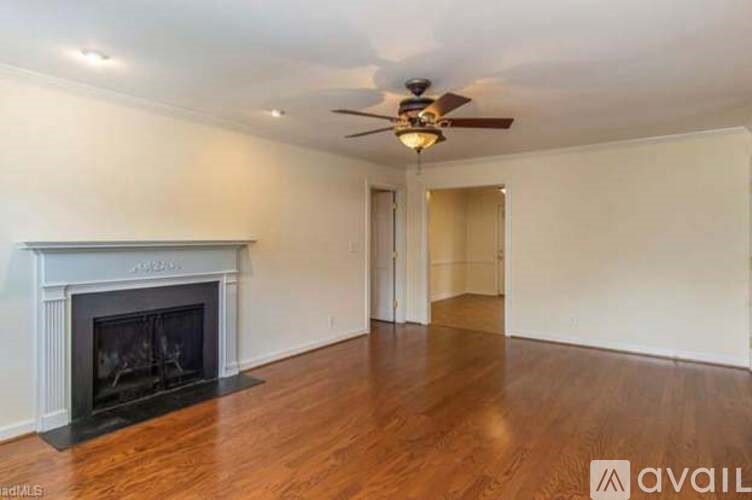 A spacious room with a fireplace and a ceiling fan.