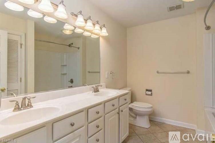 A bathroom with a white sink and a white toilet.