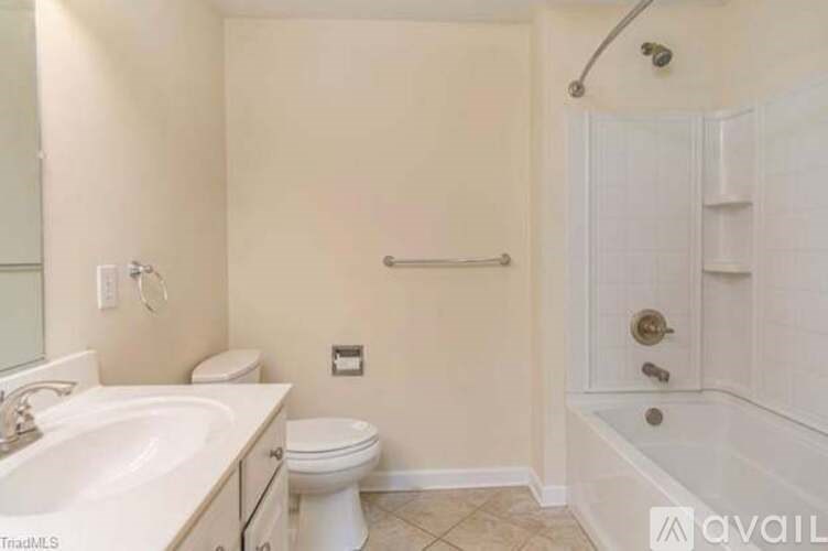 A white bathroom with a toilet, sink, and bathtub.