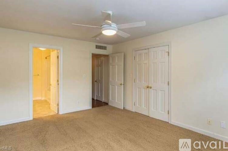 A room with a ceiling fan and two doors.