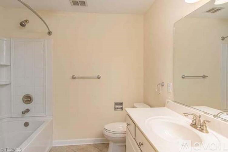 A bathroom with a toilet, sink, and bathtub.