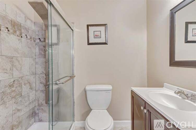 A bathroom with a toilet, sink, and shower.