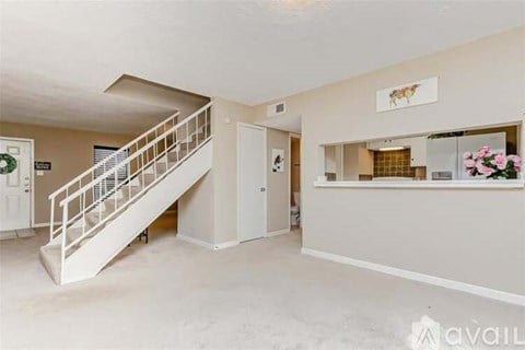 A spacious room with a staircase and a reception desk.