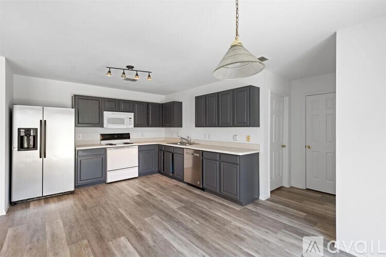 A kitchen with a refrigerator, microwave, and oven.