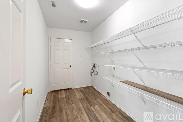 A white hallway with a door and a bicycle.