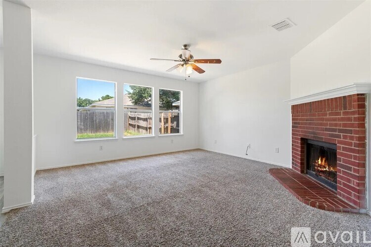 A living room with a fireplace and a ceiling fan.