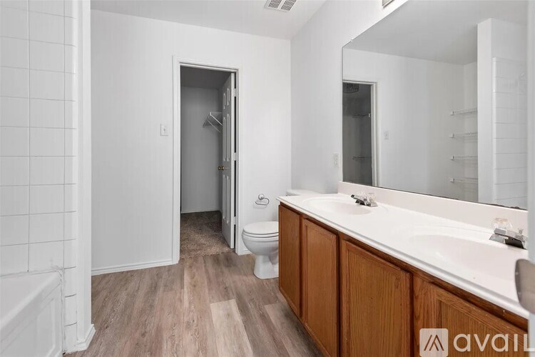A bathroom with a toilet, sink, and mirror.