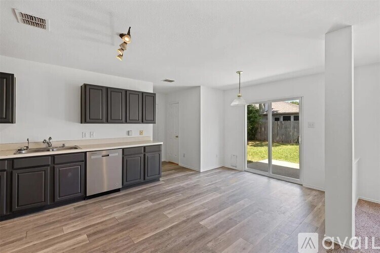 A kitchen with dark wood cabinets and a white countertop.