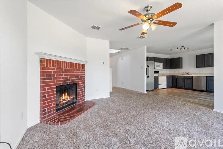 A living room with a fireplace and a ceiling fan.