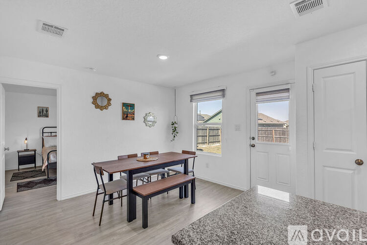A kitchen with granite countertops and a dining area with a table and chairs.